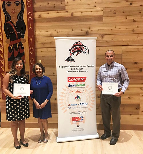 Dental students Rudy Oxendine (at right) and Brianna Chavis-Locklear (at left) were presented with scholarships at the Society of American Indian Dentists Annual Conference at the University of Washington, June 20-24, 2018. The students are pictured with Winifred J. Booker, DDS, president of the Society of American Indian Dentists.
