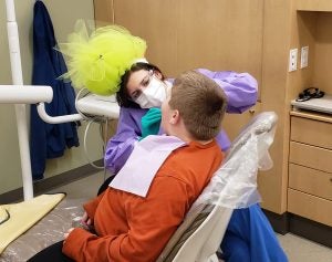 Fourth-year dental student Leslie Pence and other dental team members in Spruce Pine dressed as trolls to keep the mood light during Give Kids a Smile â day.