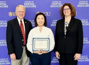 Fourth-year student Jiwon Lim received the William H. Bell Award for Predoctoral Achievement in Oral and Maxillofacial Surgery. She was congratulated by Dr. Greg Chadwick, dean of the ECU School of Dental Medicine and Dr. Michelle McQuistan, the school’s associate dean for Student Affairs.
