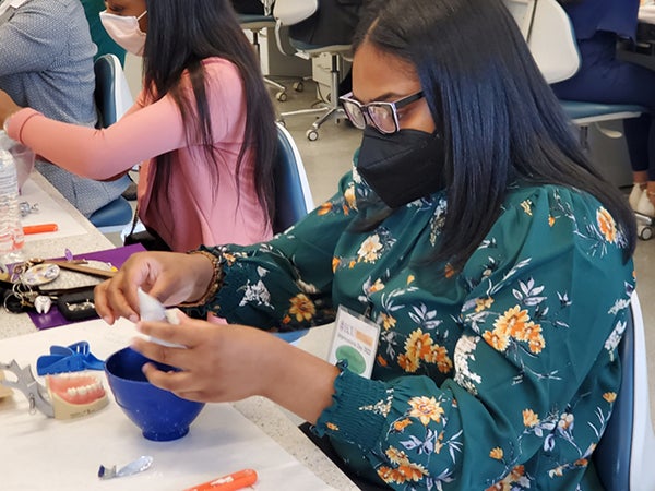 Shakiya Purcell mixes material for a dental impression during a hands-on activity at the dental school’s Impressions Day March 26. (Photo by Spaine Stephens)