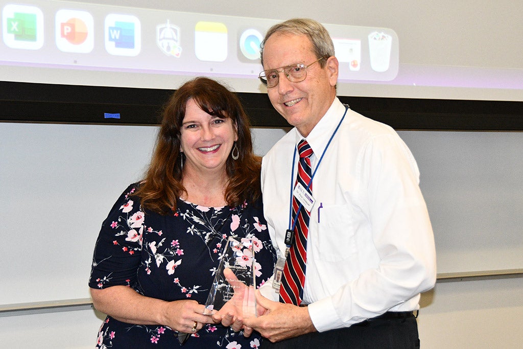 Man and woman posing with an award.