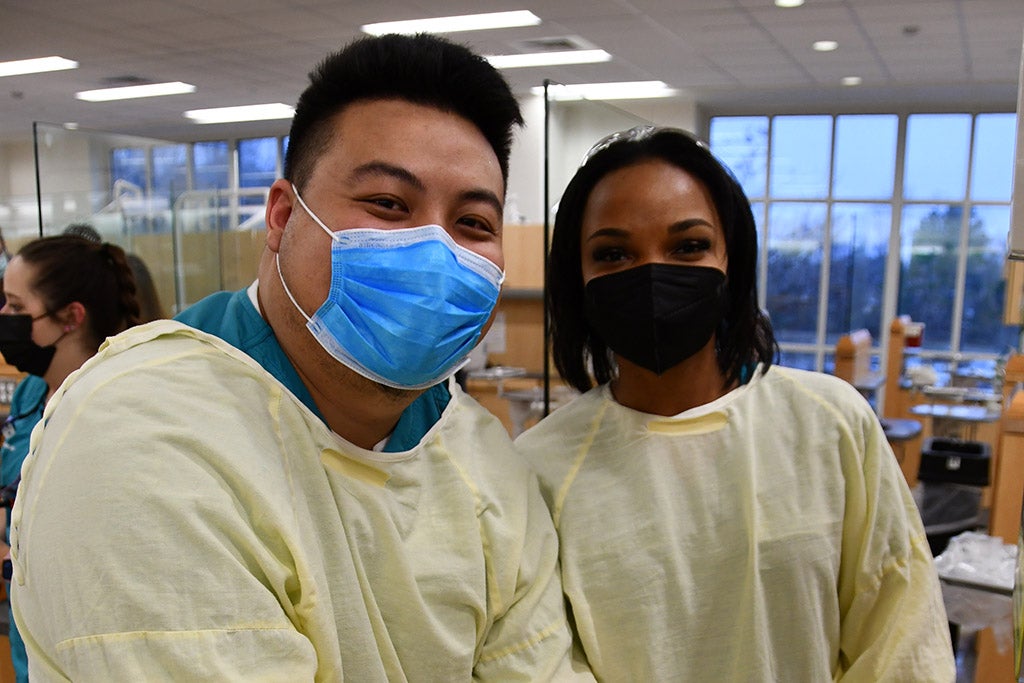 Two people with masks and surgical robes.