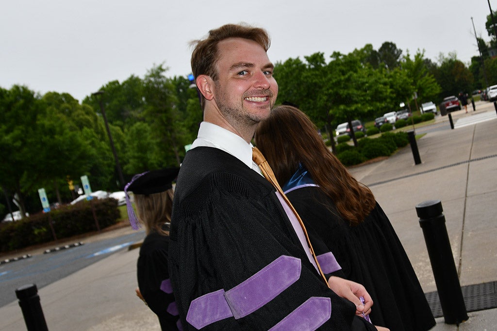 Student wearing his graduation gown.