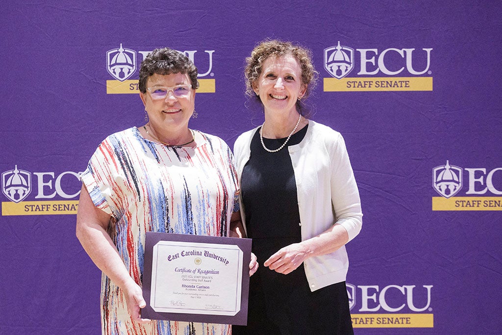Two women standing with certificate.