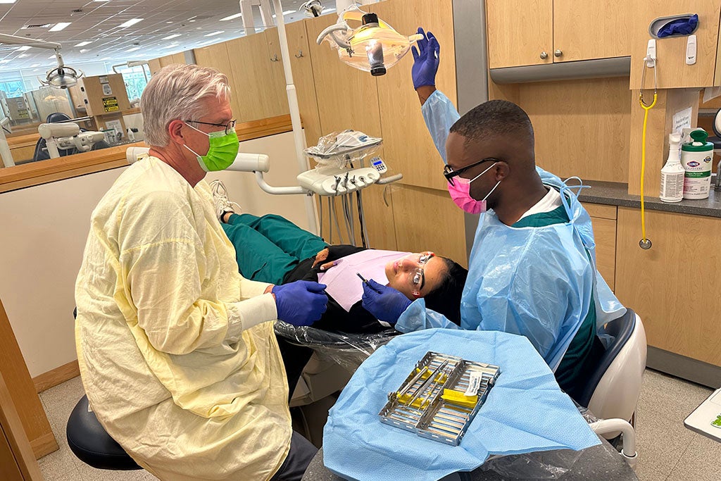 Two dentists working on a patient in a dental clinic.