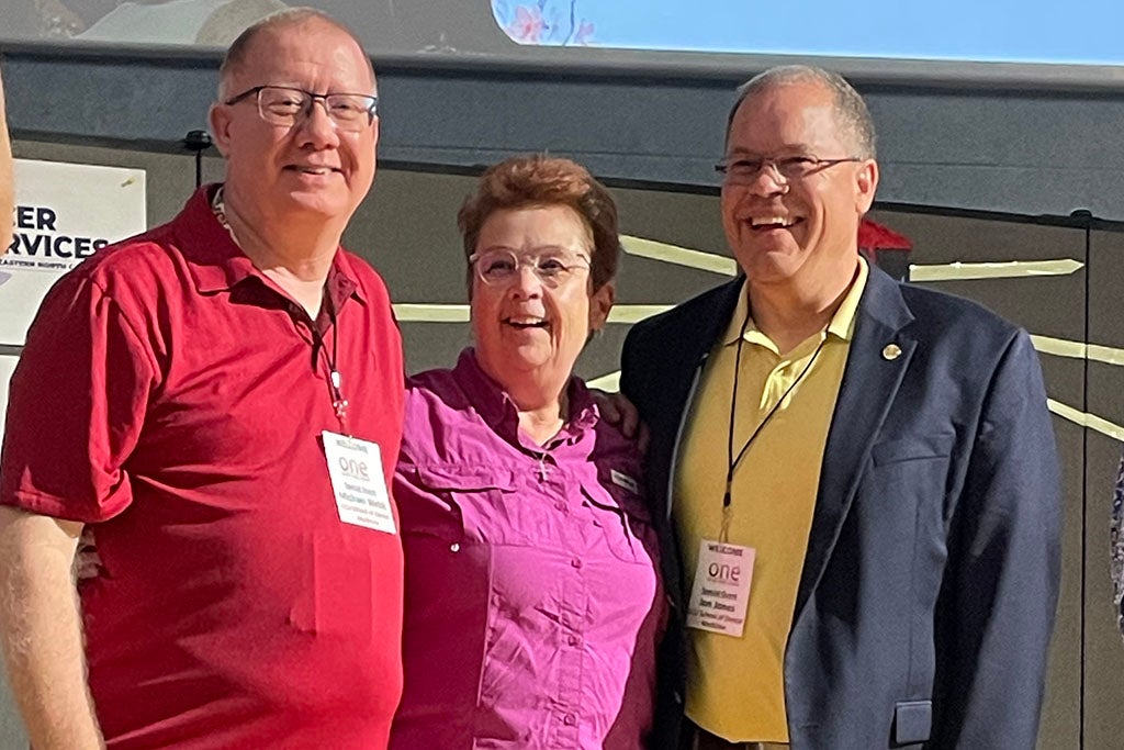 Three people in front of a building.