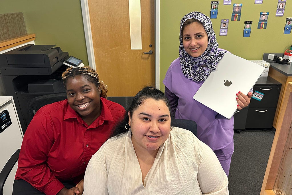 Three people at a desk.