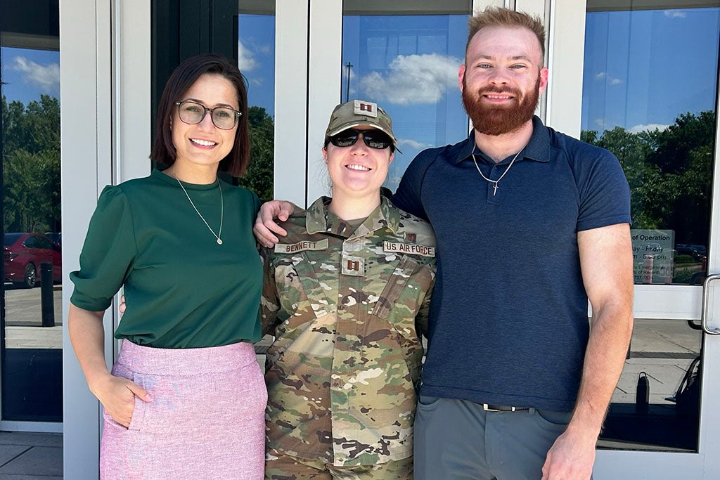 Three people in front of a building.