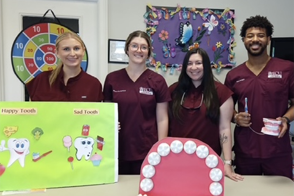 Dental students standing a table with dental props.