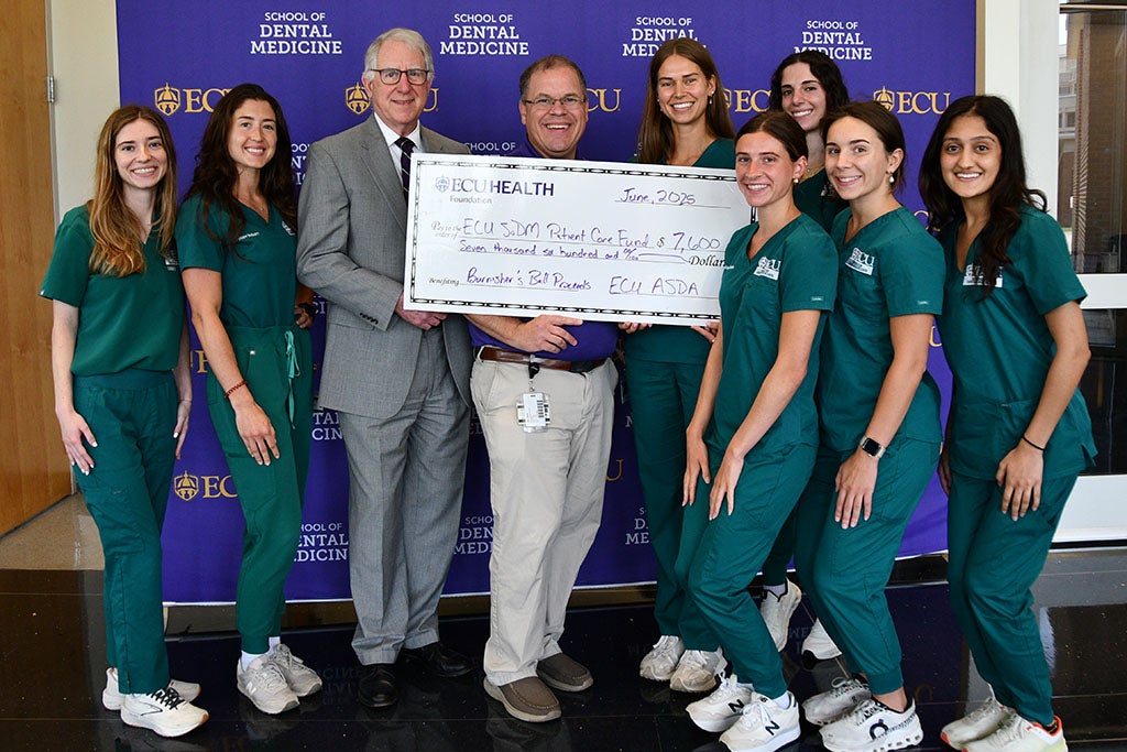 Group photo holding a large check.