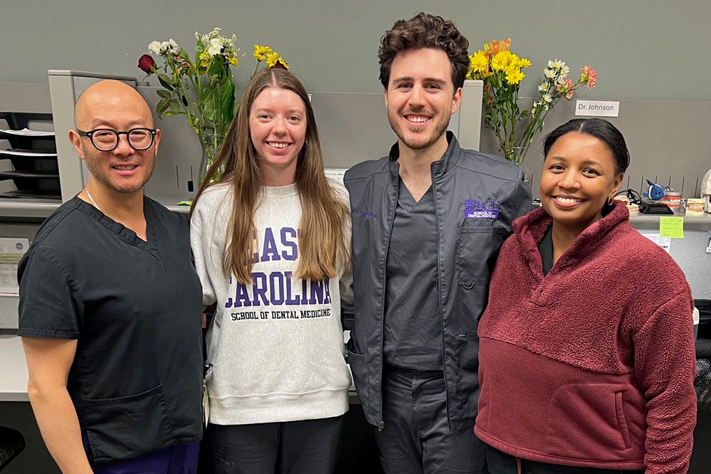 Four people in a dental office.