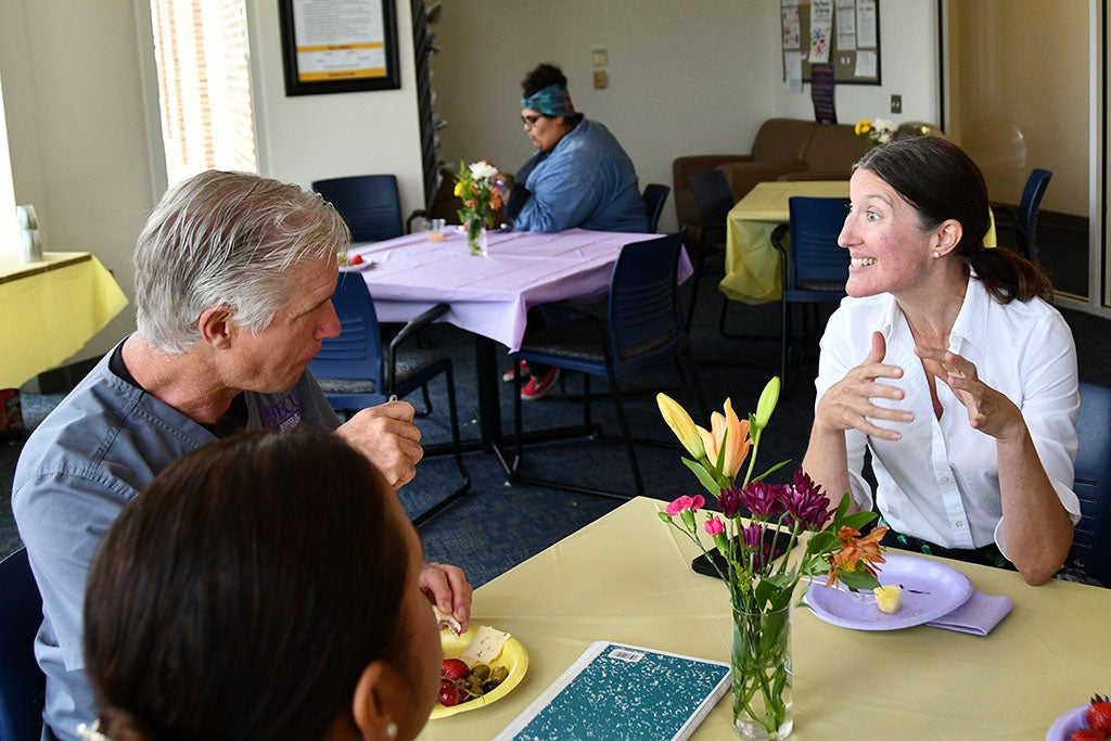 Doctors talking at table while eating lunch.