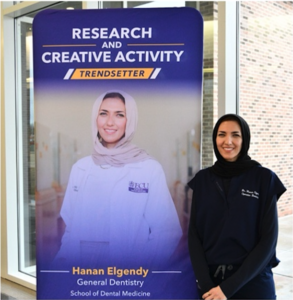 Woman standing by a poster. 