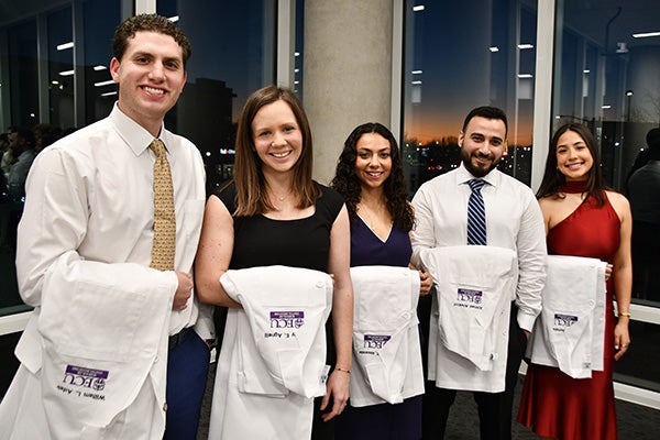 A group of people holding white coats