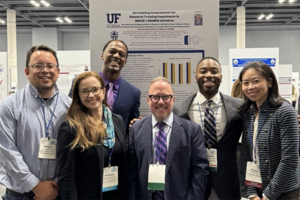 Group of people standing in front of a poster.