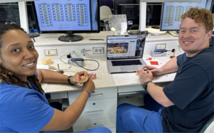 Two people in front of a computer.