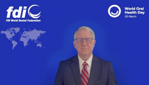 Man standing in front of blue background with logo.