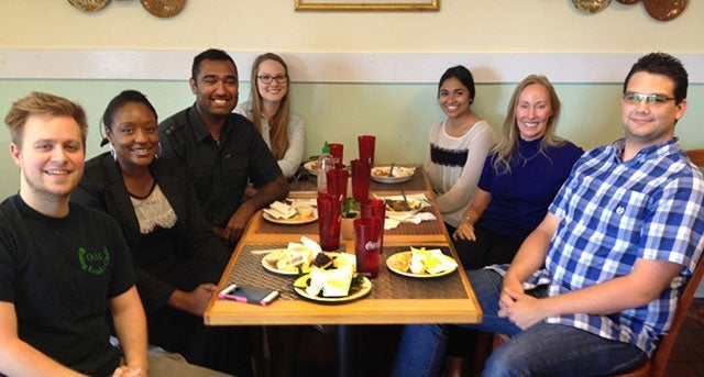 group of seven people seated around a table at a restaurant